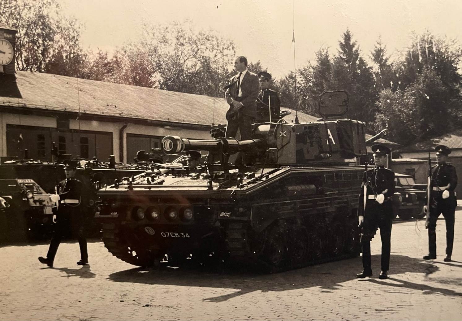 A group of men standing next to a tank
Description automatically generated with low confidence